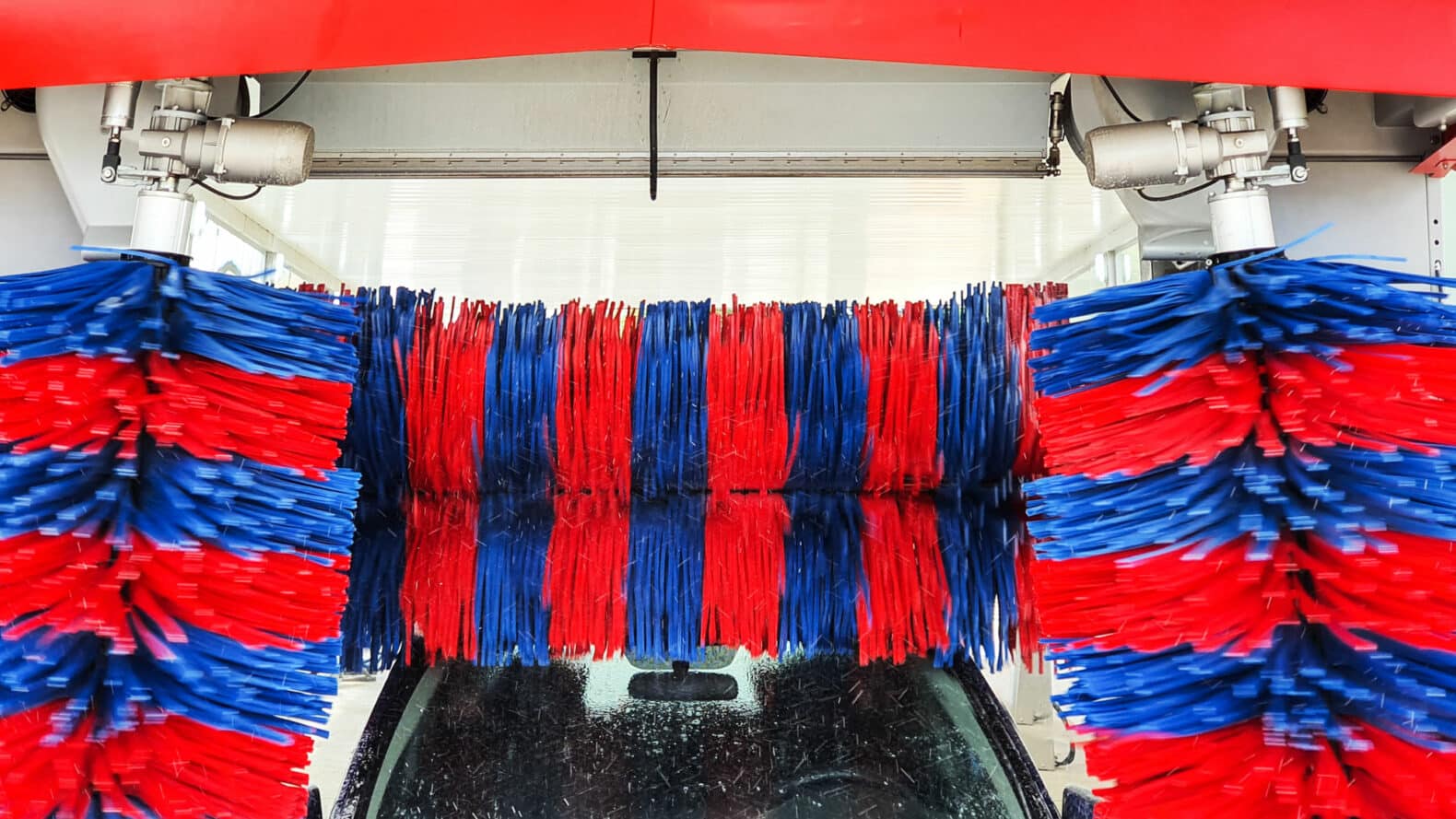 Autolavaggi Impianto di autolavaggio in funzione con spazzole e getti d'acqua